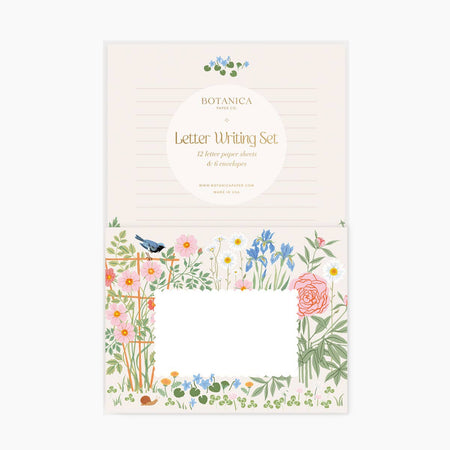 Letter writing set with ivory lined paper with blue floral design at the top. Envelopes with pink and blue wildflower floral border and white square in center for address.