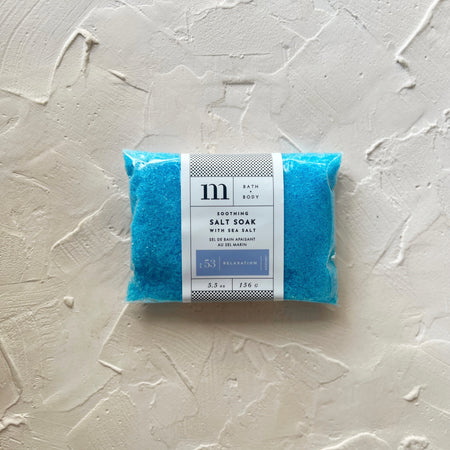 Clear plastic rectangle package with white and blue label with black text saying, “Soothing Salt Soak No 53 Relaxation”.