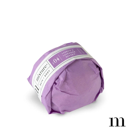 Circle ball wrapped in purple packaging with white and purple label. Black text saying, “Mixture Bath & Body Lauren’s Lavender Garden”.