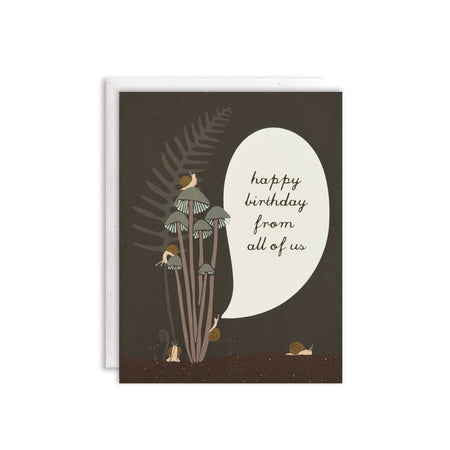 Black card with black text saying, “Happy Birthday from All of Us”. Images of various brown snails sitting on mushrooms with a green fern plant. A white envelope is included.