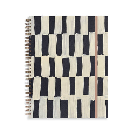 Notebook with ivory cover with black checker abstract pattern. Metal coil binding on left side. Tan elastic over right side.