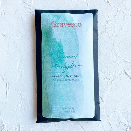 Packaged in a black rectangle pouch with white and green label with black and red text saying, “Gravesco Spearmint Eucalyptus Wax Melt”.