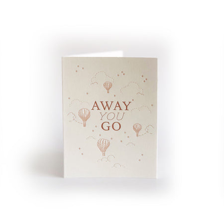 Ivory card with red text saying, “Away You Go”. Images of clouds, stars and hot air balloons. An envelope is included.