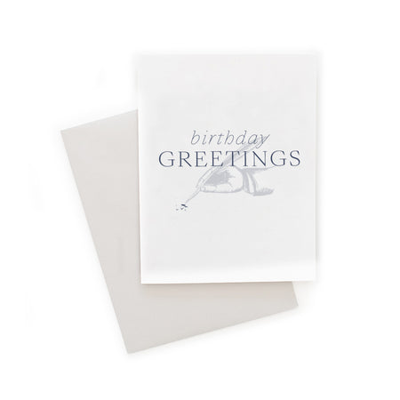 White card with silver and blue text saying, “Birthday Greeting”. Image of a hand writing with an old fashioned feather quill. A gray envelope is included.