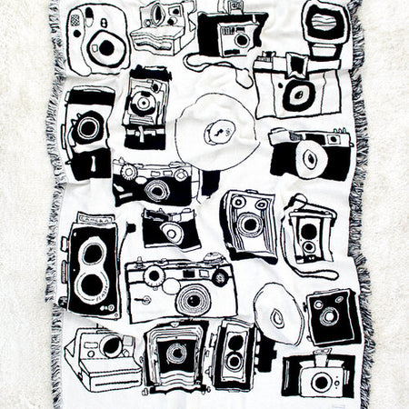 Rectangle blanket with white and black image of various vintage cameras.