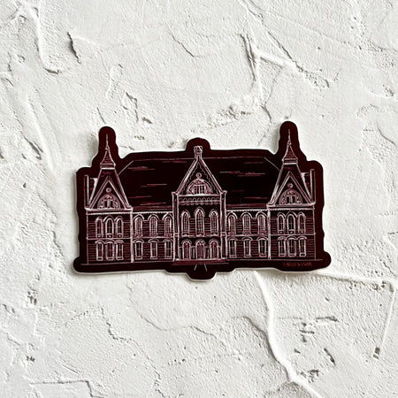 Burgundy sticker in the shape of a large mansion from Texas State University.