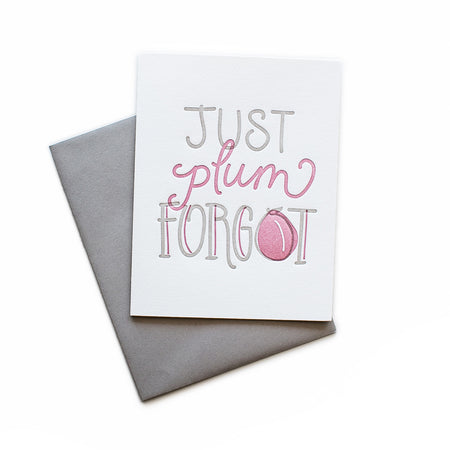 White card with gray and purple text saying, “Just Plumb Forgot”. Images of a plum fruit. A gray envelope is included.