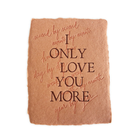 Burnt orange textured card with brown text saying, “I Only Love You More Second by Second Minute by Minute Hour by Hour Day by Day Week by Week Month by Month Year by Year”. A gray envelope is included.