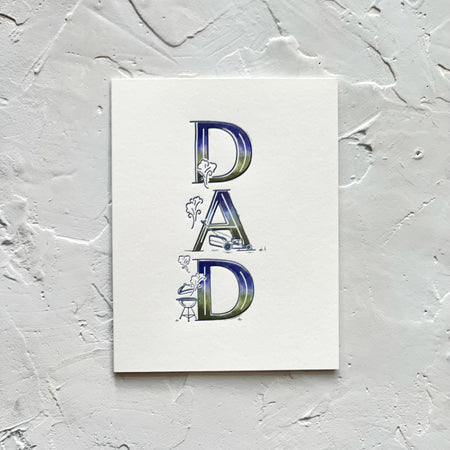 White card with variegated text in green, blue and white saying, “DAD”. Images of a lawn mower and bbq grill. An envelope is included.