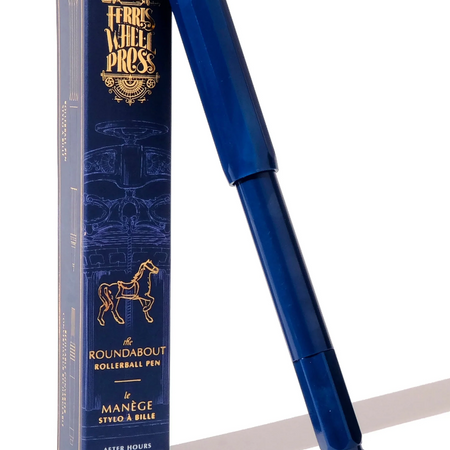 Blue pen with black and silver tip. Blue cap. Packaged in blue box with gold text saying, “Ferris Wheel Press” with image of a carousel horse.