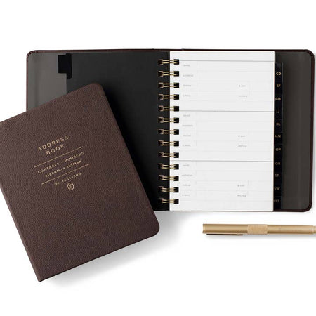 Brown address book with gold foil text saying, “Address Book Contacts & Numbers Signature Edition” in center. Gold coil binding on left side.