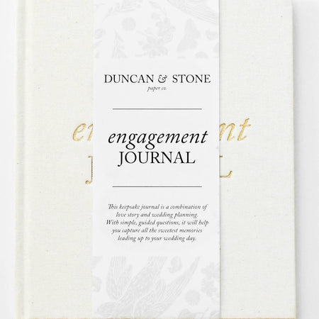 Ivory color journal with gold foil text saying, “Engagement  Journal” in center.