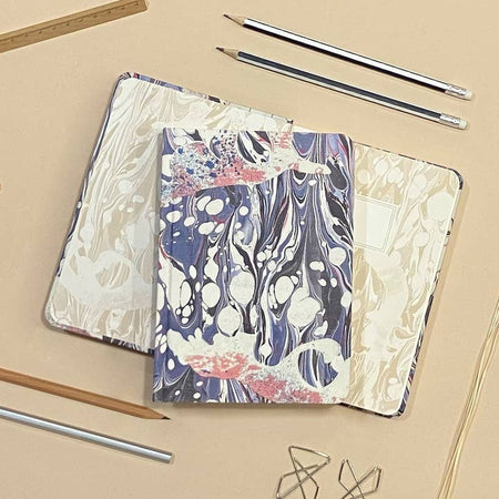 Hardcover journal with marble design including pink, purple, blue, gray, and white colors.