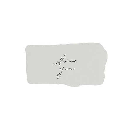 Light gray rectangle with torn edges and black text saying, “Love You”.