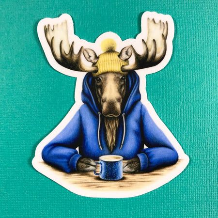 Sticker with images of a moose wearing a blue hoodie sweatshirt and a yellow ski hat drinking a cup of coffee out of a blue mug.