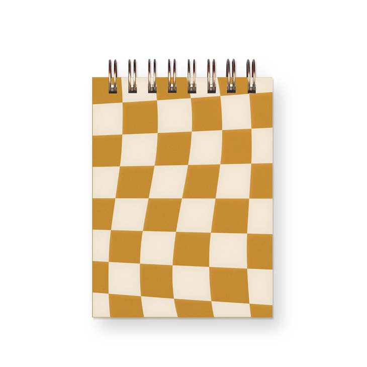 Notebook with ivory and orange checkerboard design. Metal coil binding across the top.