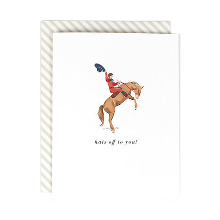 Ivory card with black text saying, “Hats Off to You!” Image of a man riding a horse holding a black cowboy hat. An ivory envelope is included.