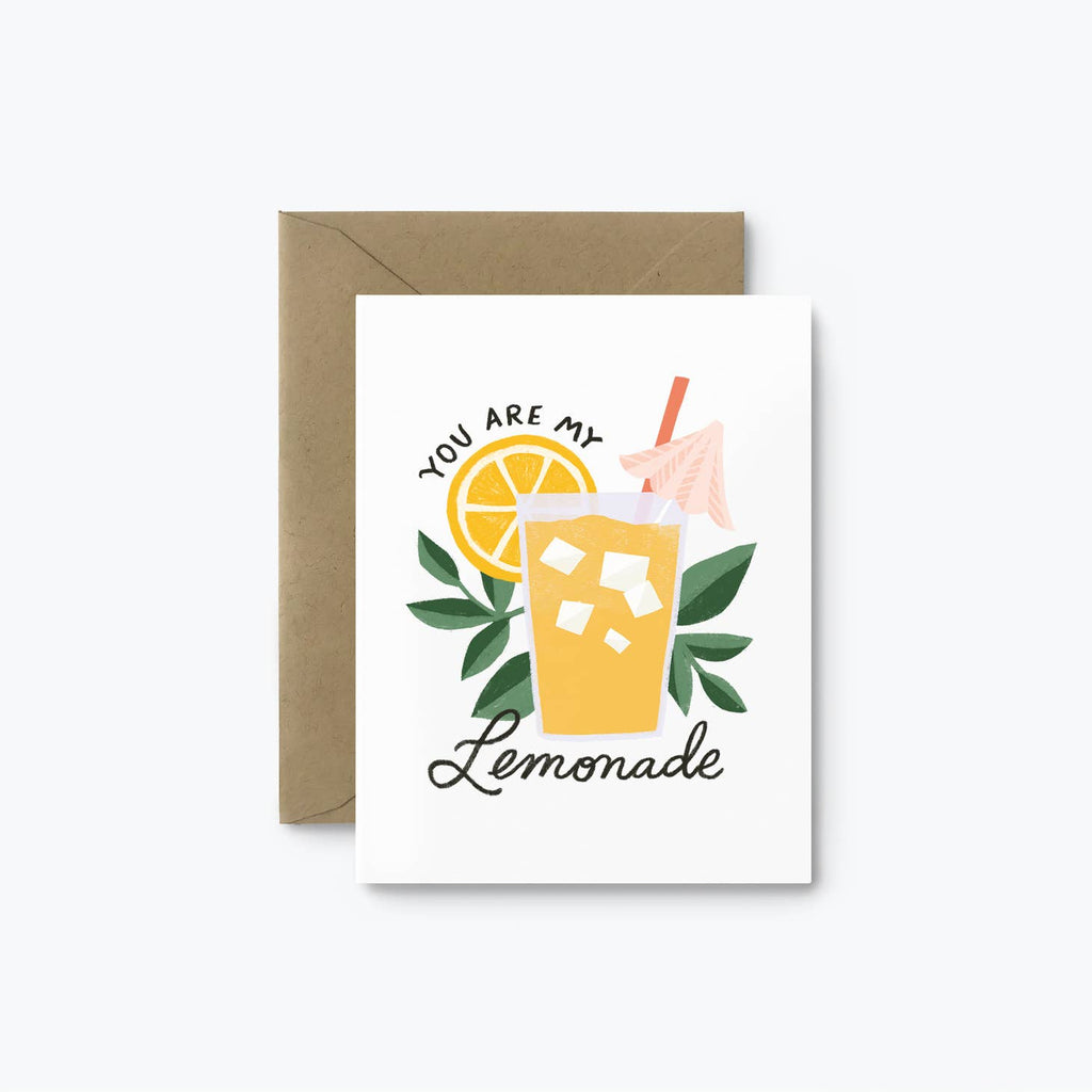 White card with black text saying, “You Are My Lemonade”. Images of a glass of yellow lemonade with ice and a pink umbrella with a lemon slice and green leaves in background. A brown kraft envelope is included.