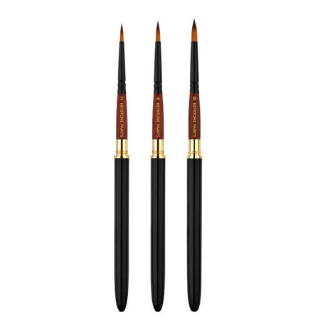 Rounded paintbrush with black and brown handle; gold middle band and brown bristles.