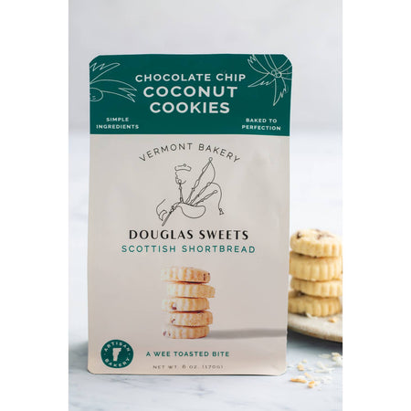 White package with green border on top with white and black text saying, “Douglas Sweets Vermont Bakery Scottish Shortbreads Chocolate Chip Coconut Cookies”. Image of a stack of shortbread cookies and outline of a man playing bagpipes.