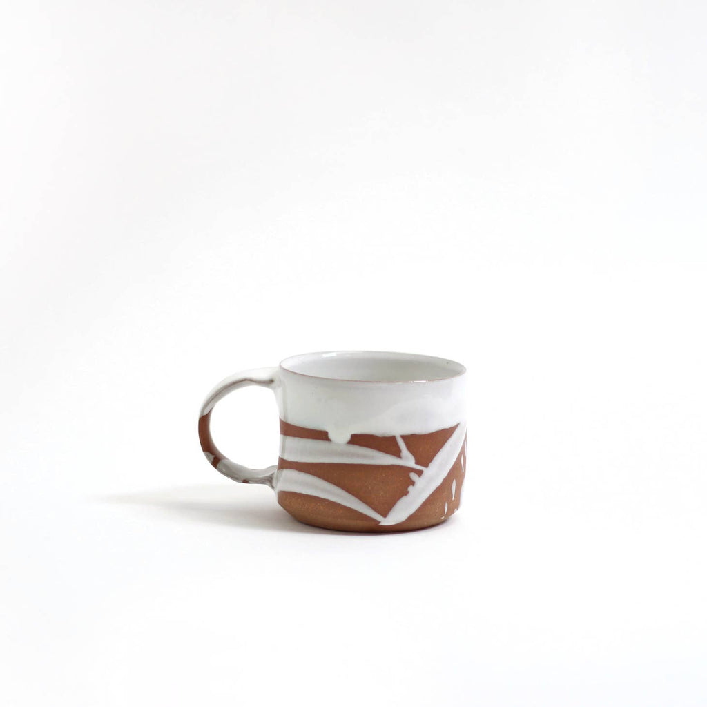 Brown mug with white painted rim and brushstrokes across mug.