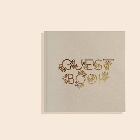 Gray cover with gold foil text saying, “Guest Book”. Lettering has floral accents.