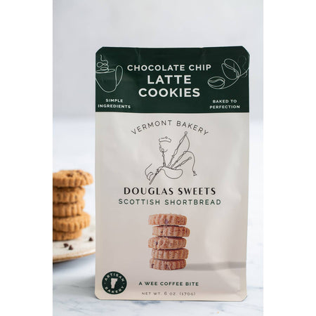 White package with green border on top with white and black text saying, “Douglas Sweets Vermont Bakery Scottish Shortbreads Chocolate Chip Latte Cookies”. Image of a stack of shortbread cookies and outline of a man playing bagpipes.