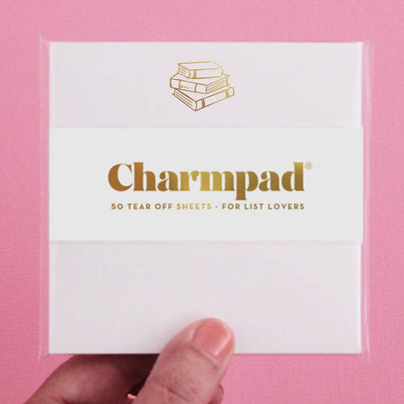 White square notepad with gold foil stack of books in top center.