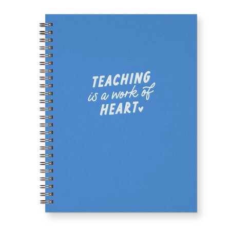 Ocean blue cover with white text saying, “Teaching is a Work of Heart” with image of a small white heart. Metal spiral coil binding on left side.