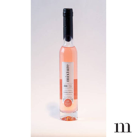 Grapefruit and Sweet Vanilla scented pink colored bubble bath packaged in a tall glass bottle.