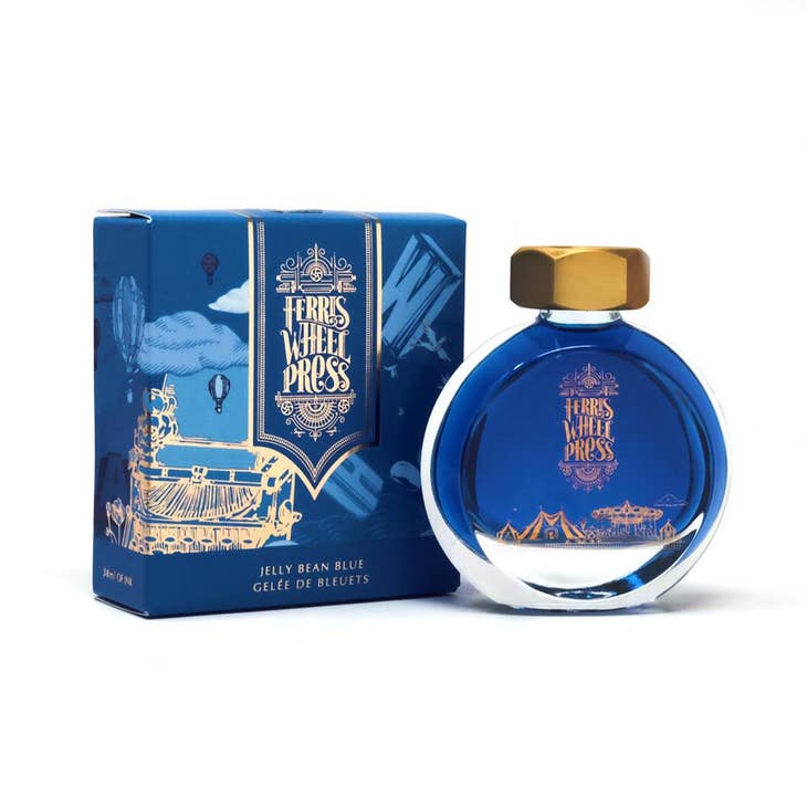 Round glass bottle with gold cover and gold text saying, "Ferris Wheel Press" with images of a carnival on front of bottle. Ink is blue. Packaged in square blue box with images of a vintage typewriter and a hot air balloon.