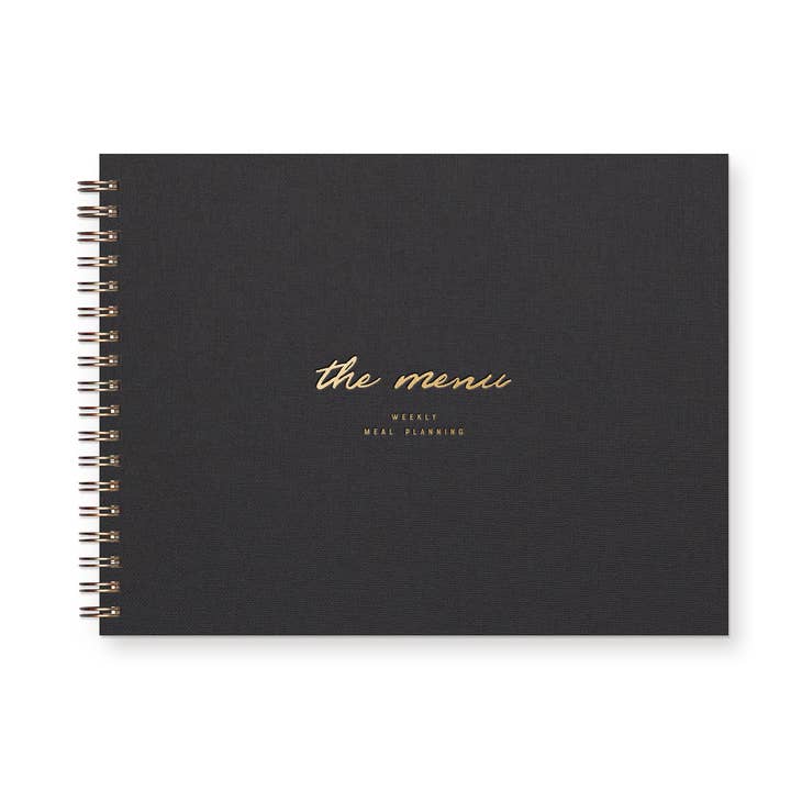Notebook with black linen cover with gold foil text saying, "The Menu Weekly Meal Planning". Metal coil binding on left side.