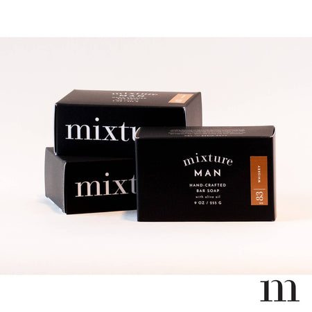 Rectangular black package with white text saying, “Mixture Man Handcrafted Bar Soap”.
