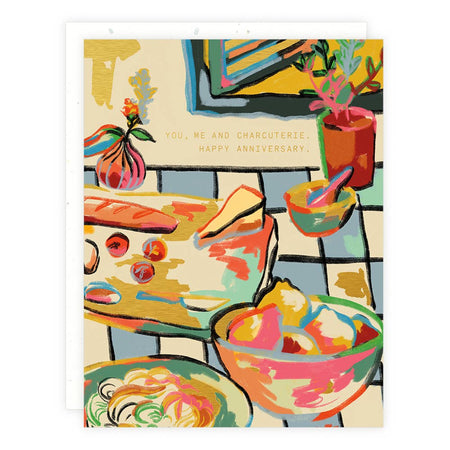 Ivory card with gold foil text saying, “You, Me and Charcuterie. Happy Anniversary.” Image of a table set with drinks and a charcuterie board. A white envelope is included.