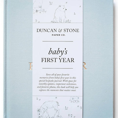   Sky blue color journal with gold foil text saying, “Baby’s First Year” in center.
