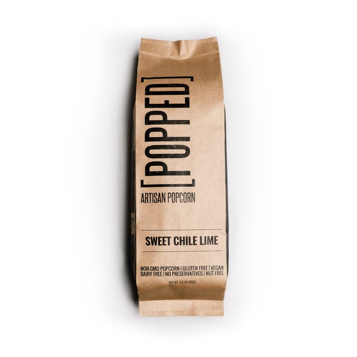 Packaged in a brown and black paper bag. Black text saying, 