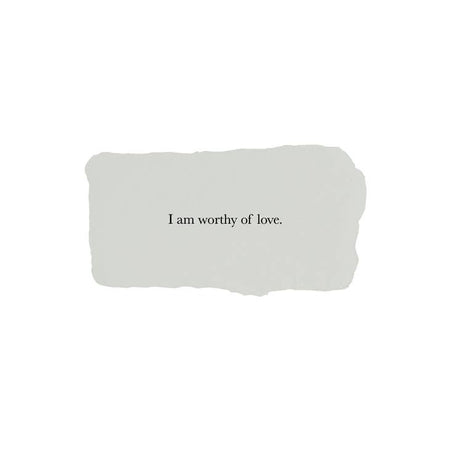 Gray rectangle with torn edges and black text saying, “I am Worthy of Love”.