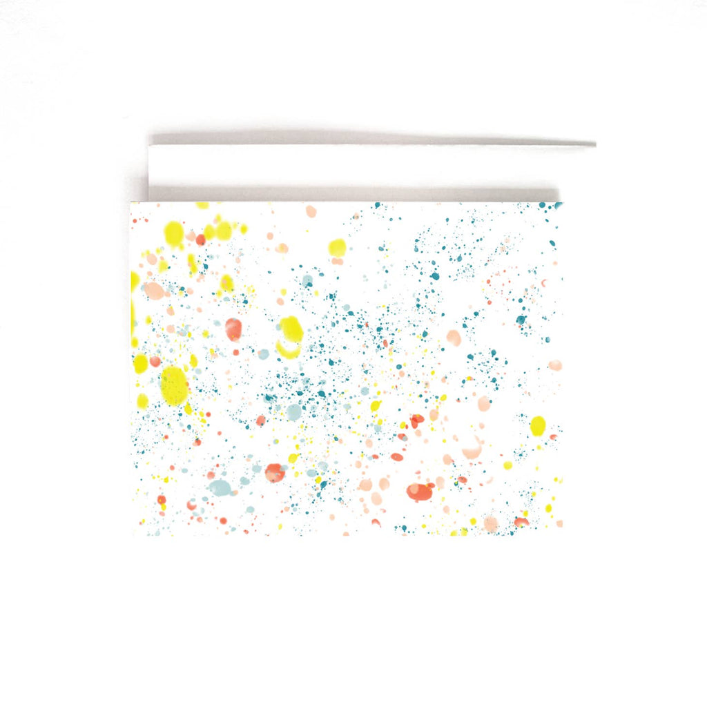 White card with yellow, blue, pink, red and green paint splatters scattered across card. A white envelope is included.