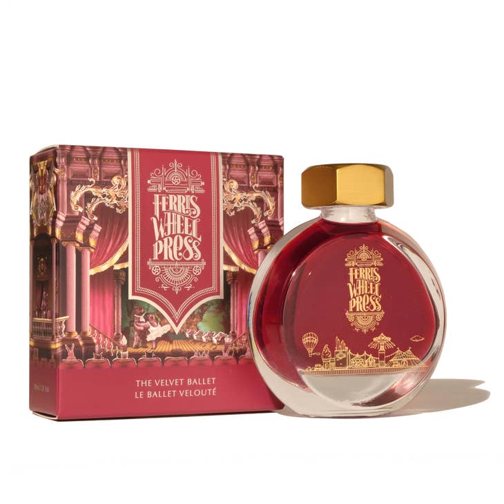 Round glass bottle with gold cover and gold text saying, "Ferris Wheel Press" with images of a carnival on front of bottle. Ink is red. Packaged in square red box with images of a theater with ballerina bears on stage.