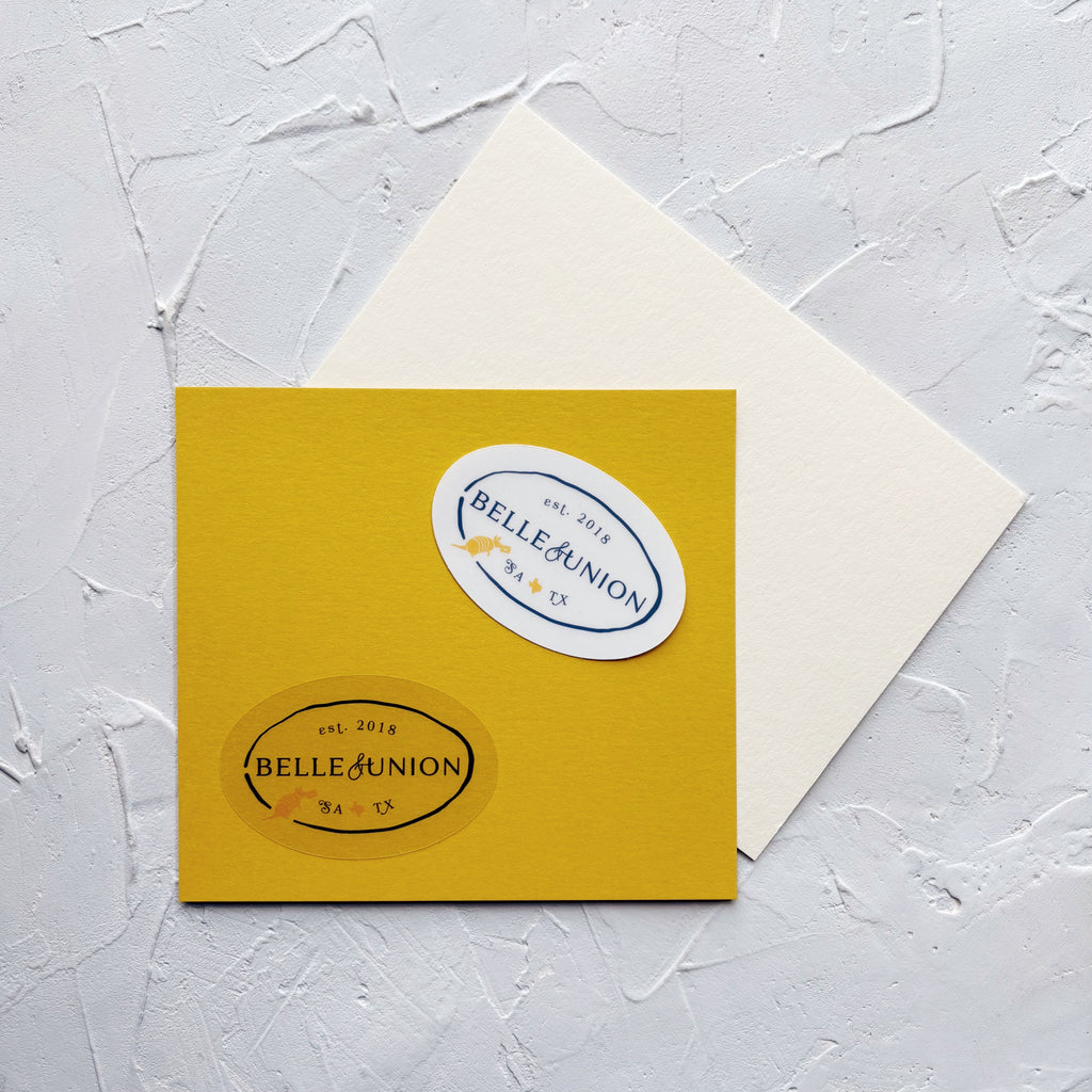 two oval belle & union stickers with navy text and a yellow texas and armadillo icon. both on yellow paper.
