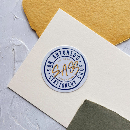 Round Belle & Union sticker with navy text and 