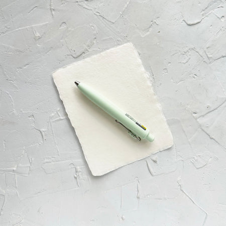 Light green pen on textured white background. 