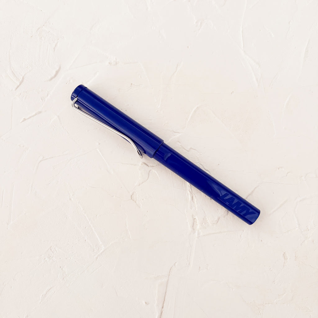 blue capped pen on textured white background