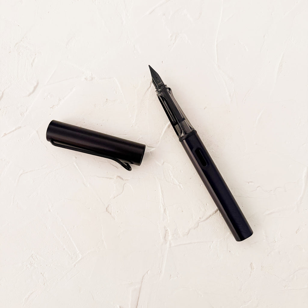black fountain pen on textured cream background