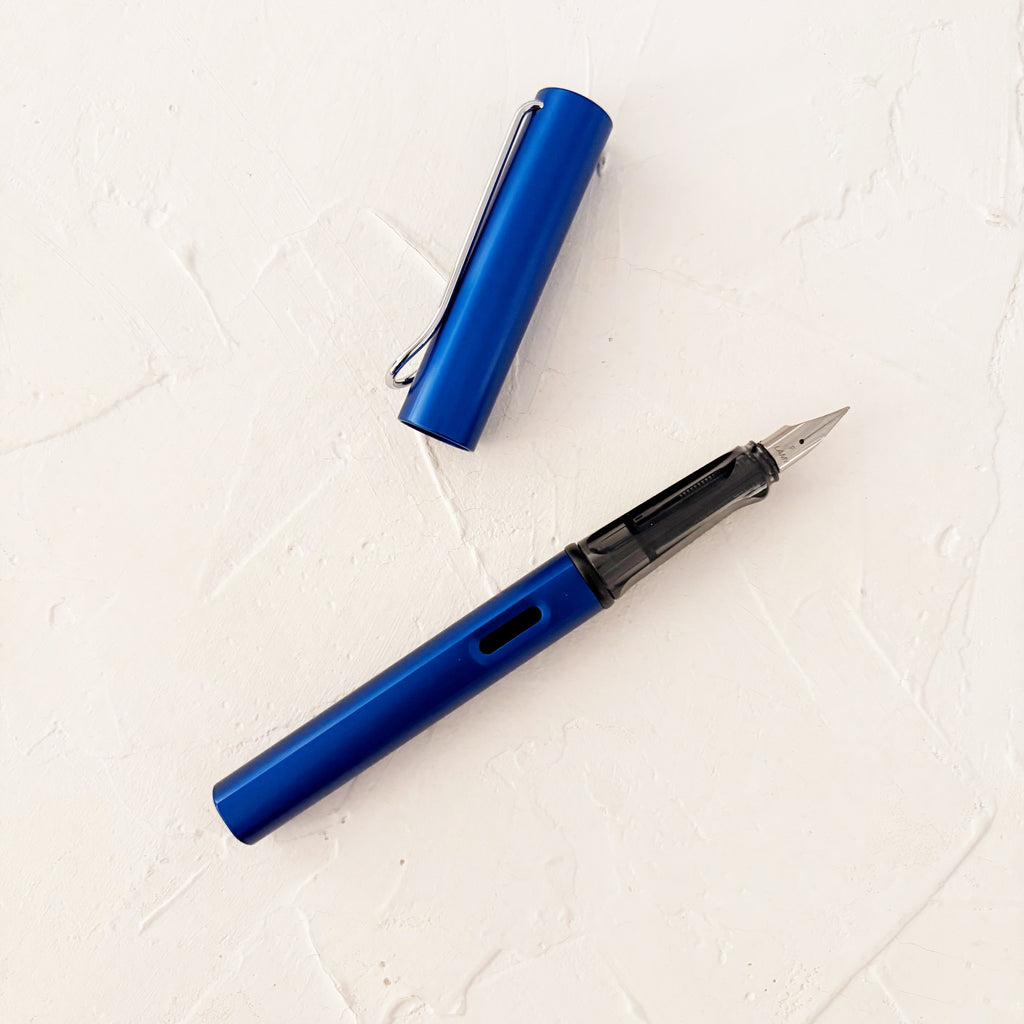 blue fountain pen on cream textured background