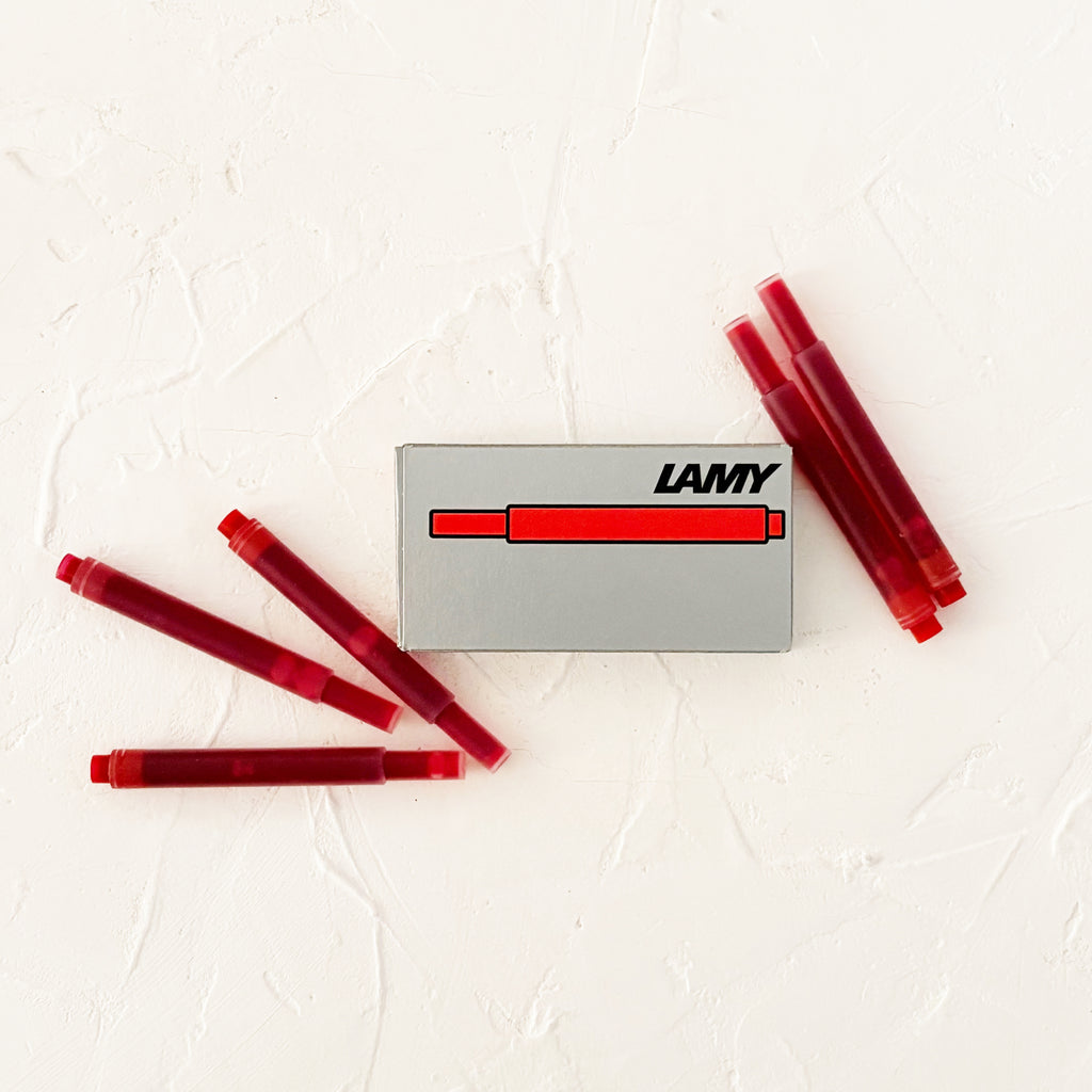 red ink cartridges on textured white background
