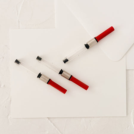 3 fountain pen converters on white paper