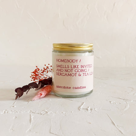 Glass candle with gold lid on textured background