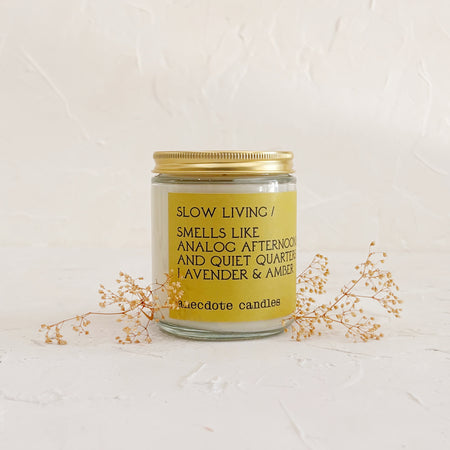 Glass candle with gold lid on textured background