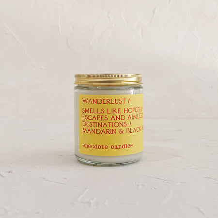 Glass candle with gold lid on textured background